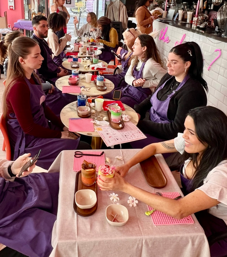 Une équipe en tabliers violets en plein atelier bougies à l’Atelier Lili