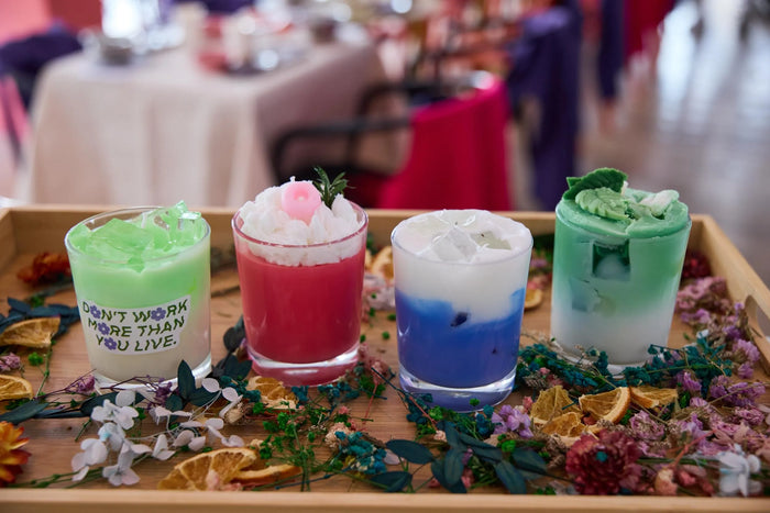 Bougies colorées réalisées en atelier, posées sur une table de fête